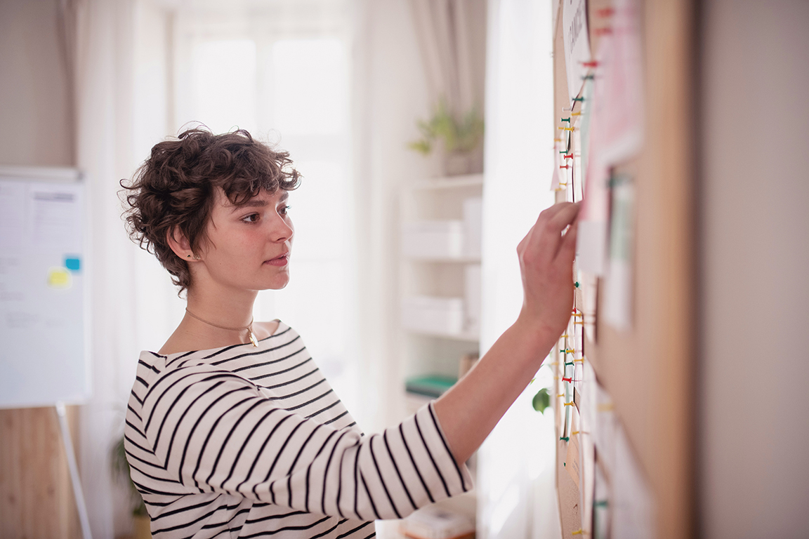 Jeune experte-comptable devant un tableau RSE - Atlas