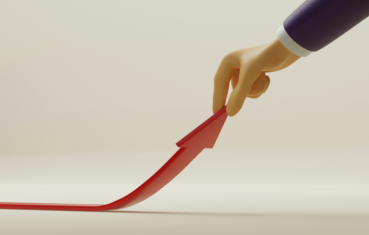 Main tenant une flèche rouge orientée vers le haut,  symbolisant la croissance, la progression de carrière et les  perspectives d’évolution dans les métiers de l’expertise  comptable et de l’audit.